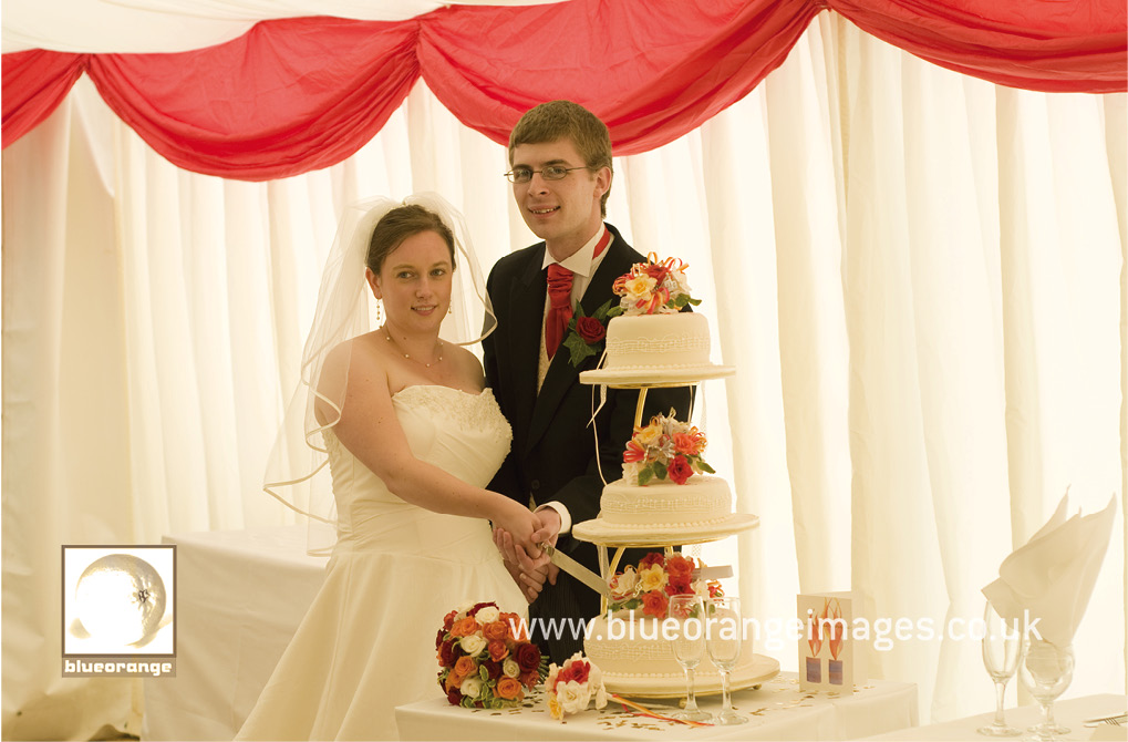 Hannah and John, the bride and groom, cutting the wedding cake